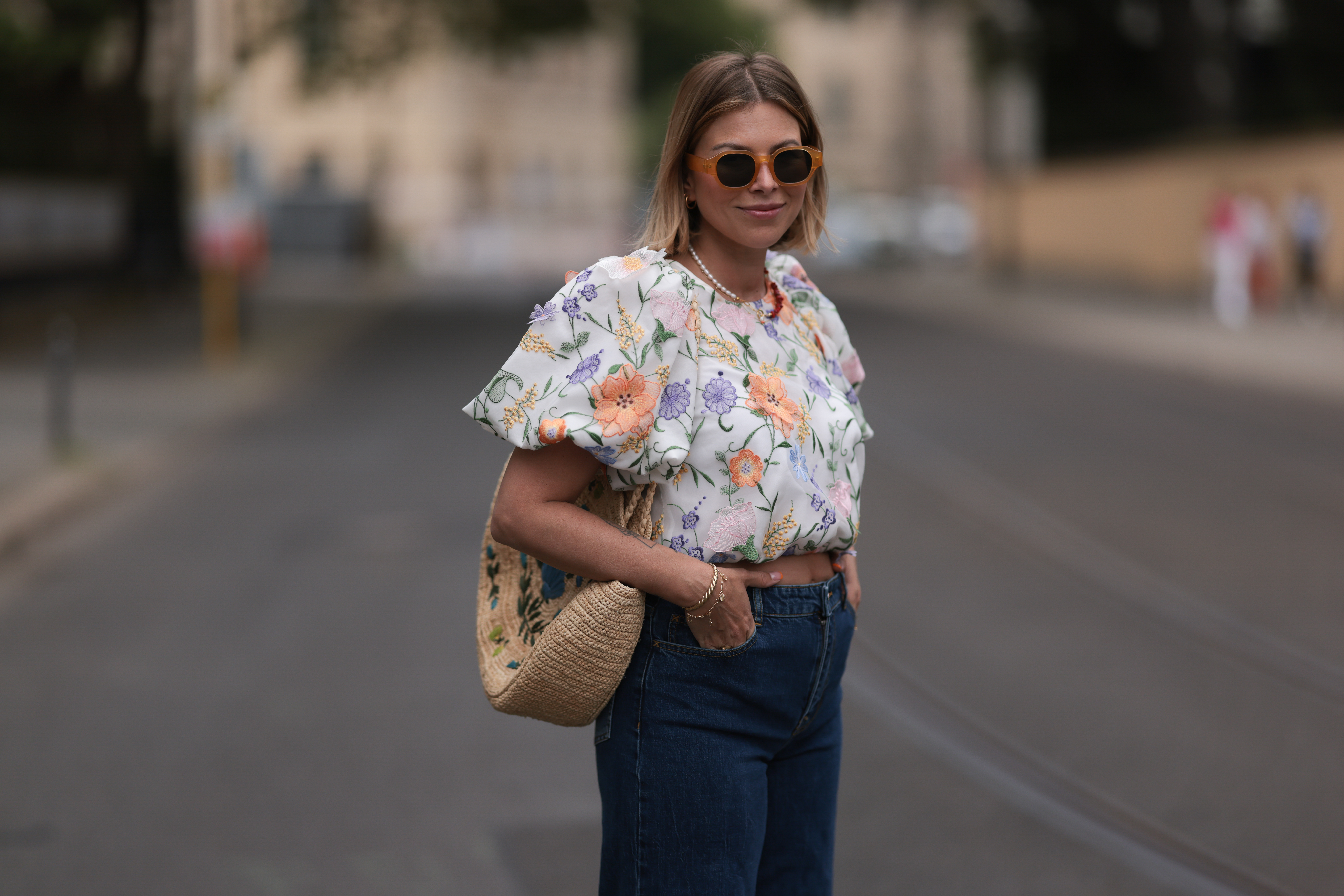 Aline Kaplan wearing Baum & Pferdgarten wide leg blue denim pants, & other stories white flower pattern cropped blouse and orange summer heels and Mango orange black shades on June 06, 2023 in Berlin, Germany.
