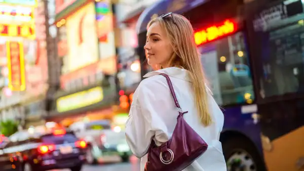 A cheerful young Caucasian woman exploring the city.