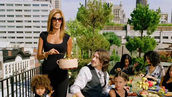 Woman wearing chic summer outfit in NYC, accessorized with sunglasses and designer-style handbag