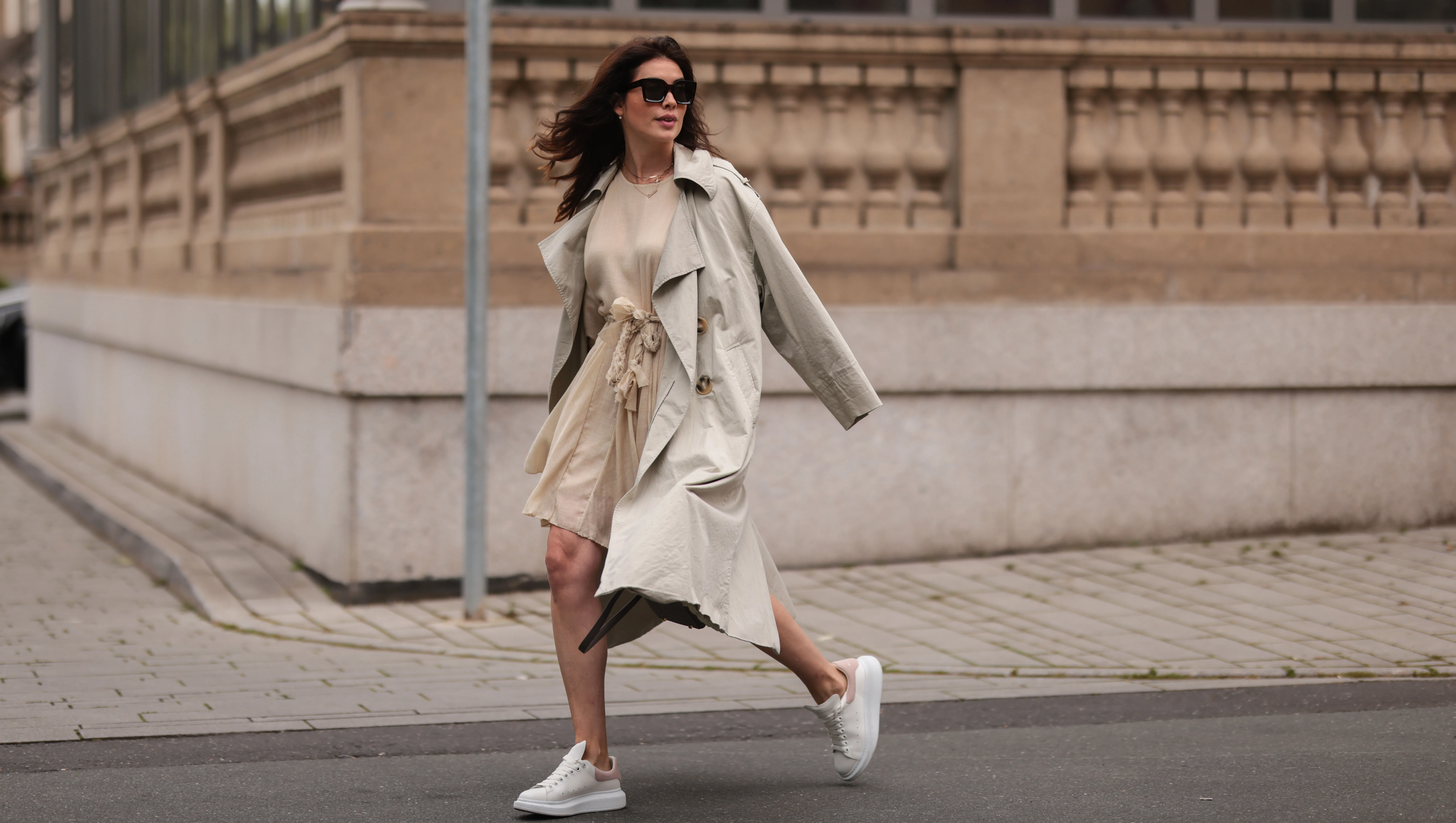 DUSSELDORF, GERMANY - AUGUST 07: Ira Meindl wearing Mango beige trenchcoat, Hermes grey leather bag, Alexander McQueen white sneaker, beige dress and Celine shades on August 07, 2021 in Dusseldorf, Germany. (Photo by Jeremy Moeller/Getty Images)