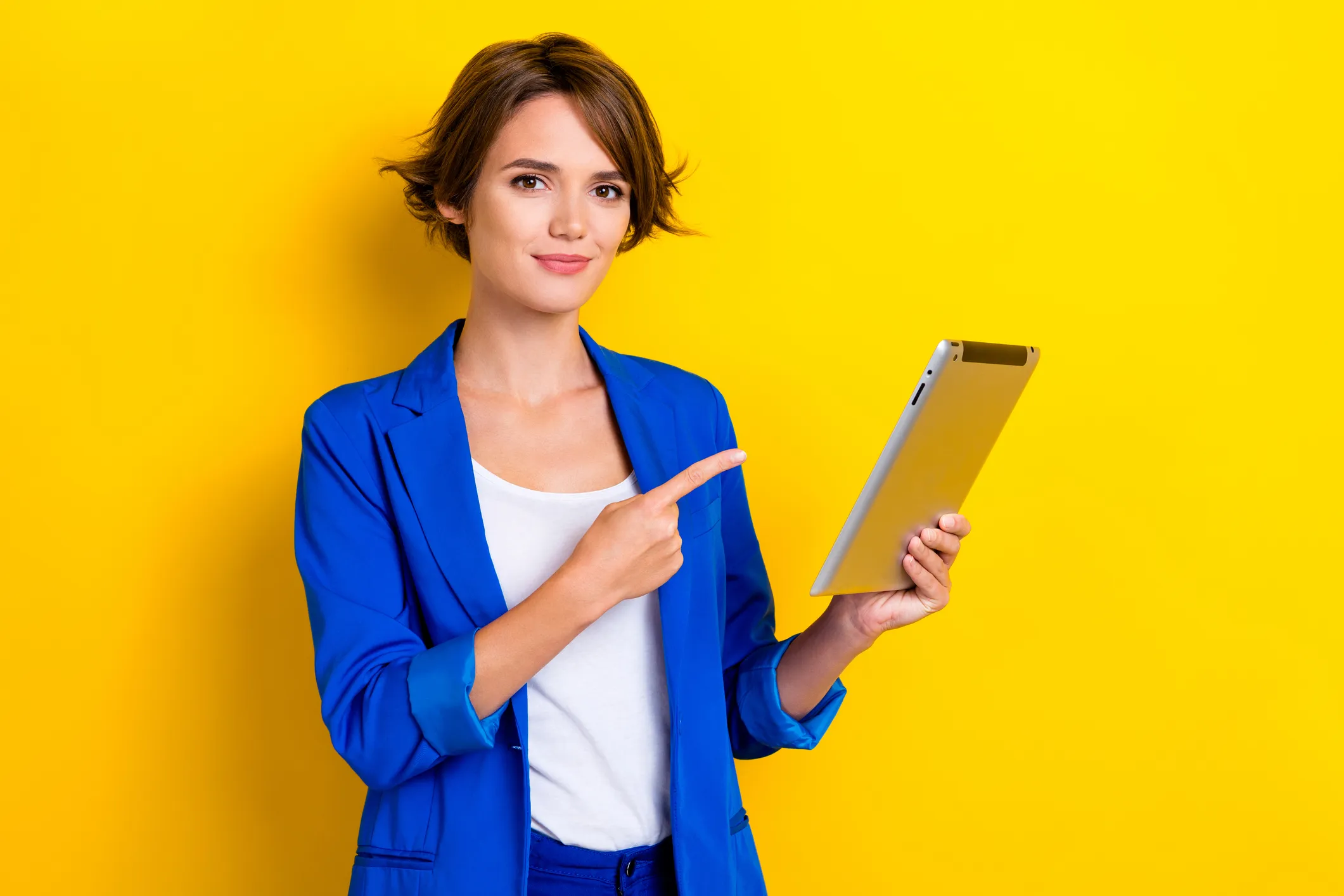 Photo of confident cheerful woman wear blue jacket pointing finger apple samsung modern gadget isolated yellow color background.