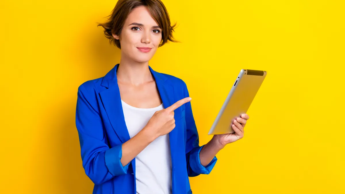 Photo of confident cheerful woman wear blue jacket pointing finger apple samsung modern gadget isolated yellow color background.