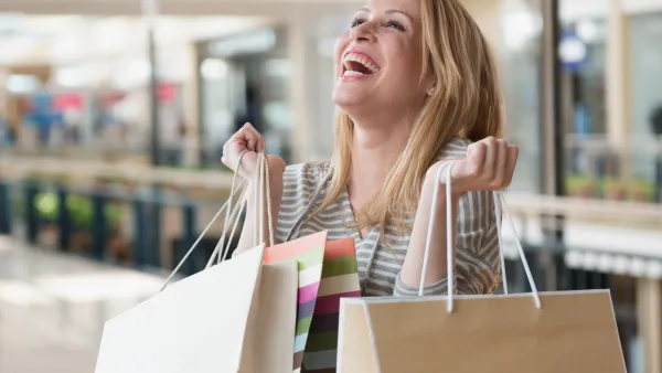 Mixed race woman carrying shopping bags in mall