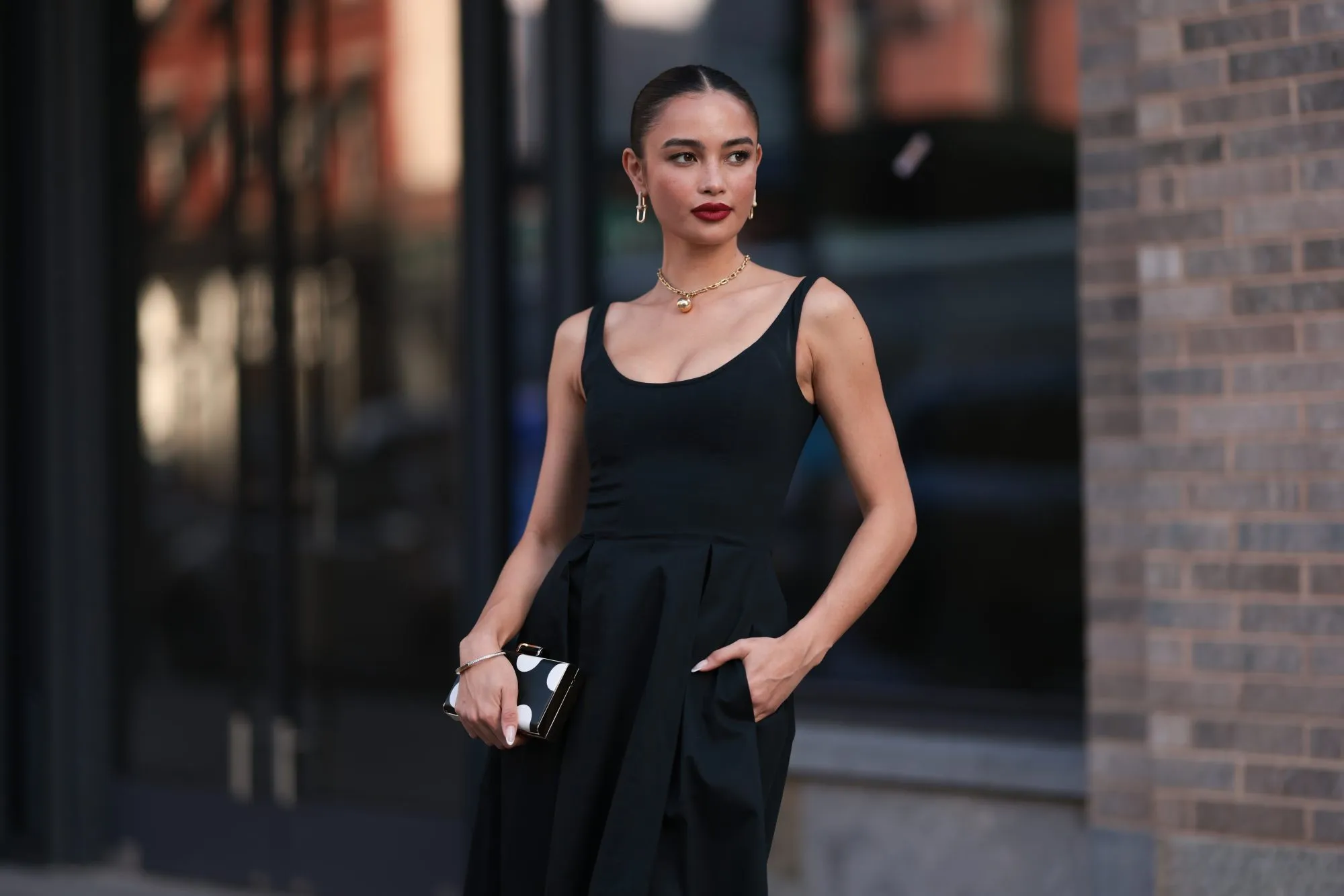 NEW YORK, NEW YORK - SEPTEMBER 12: Sara Sampaio is seen wearing yellow-gold earrings a necklace from Tiffany & Co., HardWear Collection; a sleeveless, round-necked, black midi dress; a silver bracelet; a black clutch with white polka dots before the Carolina Herrera Spring Summer 2024 Runway Show on September 12, 2023 in New York City. (Photo by Jeremy Moeller/Getty Images)