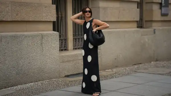 BERLIN, GERMANY - JUNE 24: Sophia Geiss is seen wearing a black and white long sleeveless polka dot knit dress with round neckline from Zara; a black Nana leather hobo bag with braided structure from abro; black PR 25YS sunglasses with rectangular biker shape from Prada; a pair of black thong sandals with kitten heel from LeGer by Lena Gercke; a pair of silver Harmonie big hoop earrings from black palms the label; a thin gold bangle from Daniel Wellington on June 24, 2025 in Berlin, Germany. (Photo by Moritz Scholz/Getty Images)