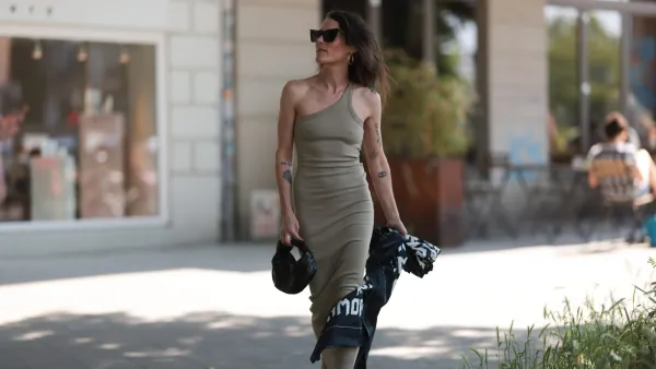 HAMBURG, GERMANY - JUNE 08: Helen Unsinn seen wearing black Gucci shoes, The Line by K beige long dress, golden LENIKA creols, Yves Saint Laurent black shades, LENIKA x Black White Grey silk scarf and Bottega Veneta mini Jodie black leather bag on June 08, 2023 in Hamburg, Germany. (Photo by Jeremy Moeller/Getty Images)