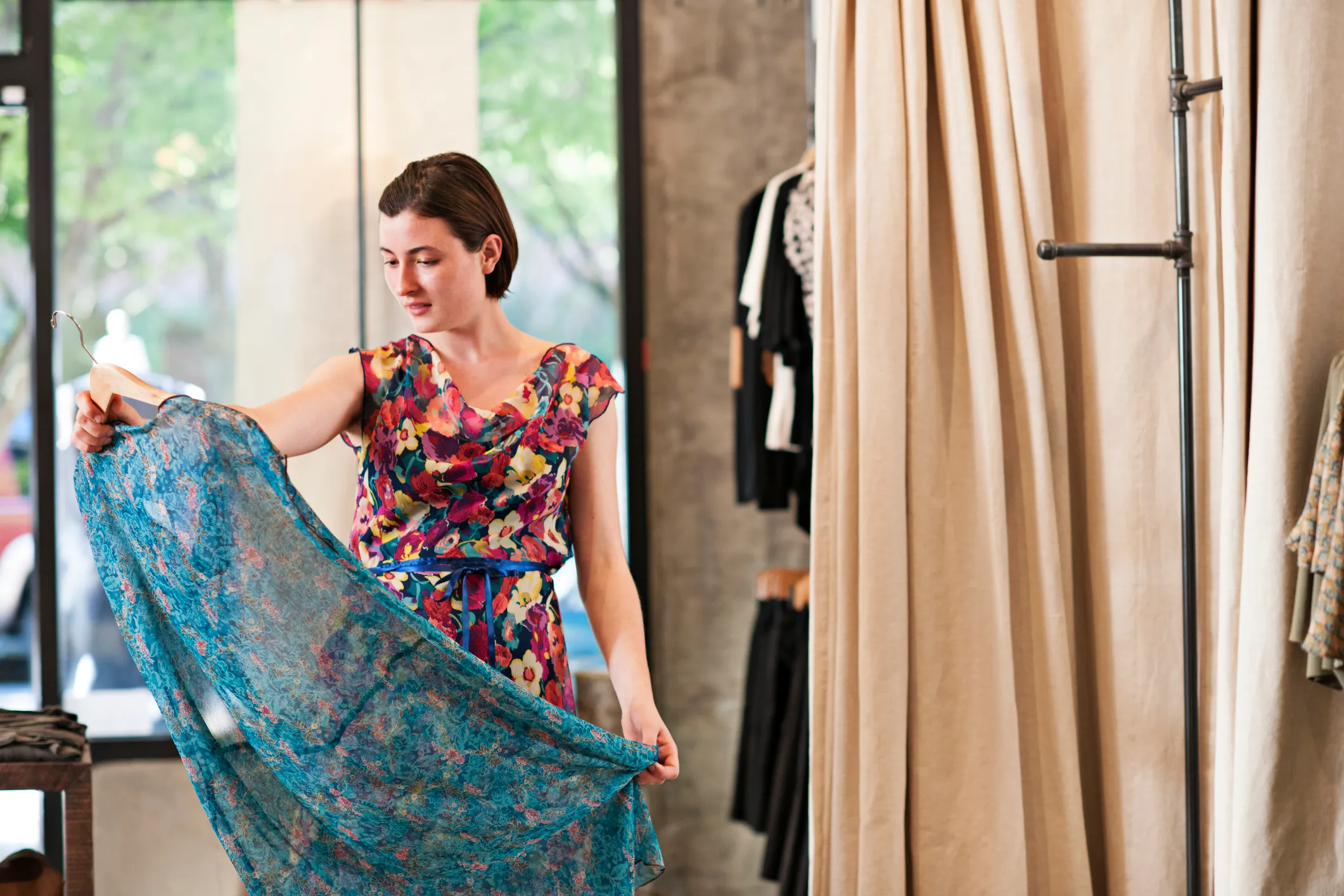 Woman in a floral dress admires another floral dress