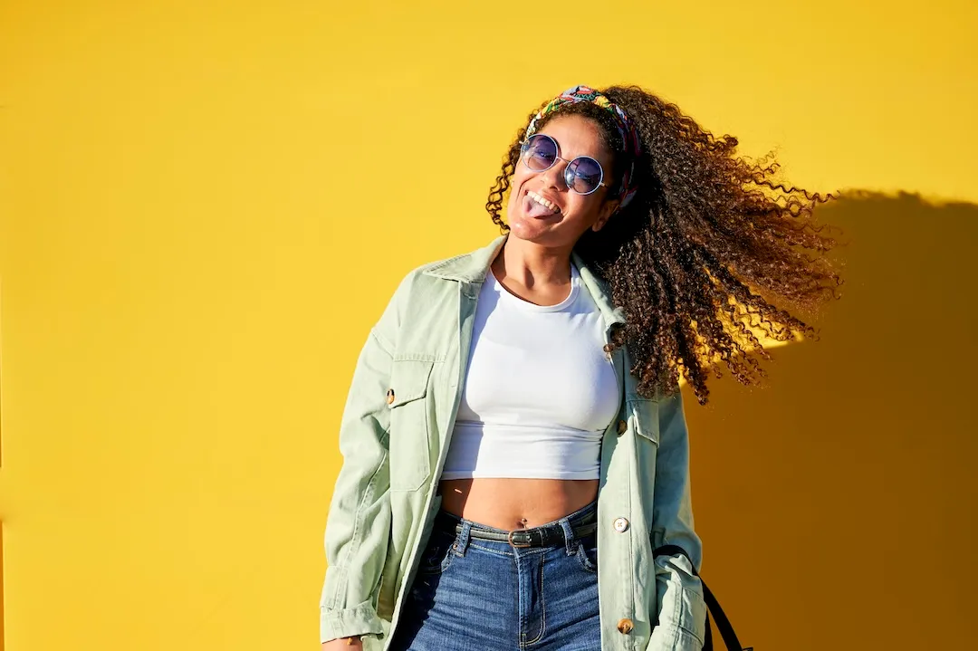 Portrait of woman with sunglasses on yellow background
