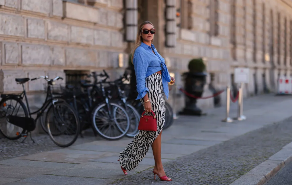 BERLIN, GERMANY - JUNE 16: Nina Suess wearing red Lanvin shades, blue Zara shirt, black and white Jacquemus skirt, red Bottega Veneta heels and red Louis Vuitton leather bag on June 16, 2021 in Berlin, Germany. (Photo by Jeremy Moeller/Getty Images)