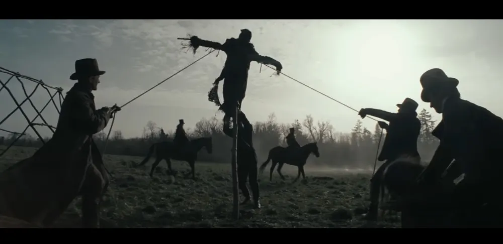 Men hoist up a scarecrow in The Cursed