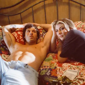 Dasha and shirtless Rob Rausch in bed in her "Like It Like That" music video.