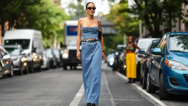 NEW YORK, NEW YORK - SEPTEMBER 10: Tamara Kalinic wears sunglasses, a blue denim off-shoulder low neck cropped top, a black leather studded belt, a blue denim maxi skirt, a black leather bag, outside Adeam, during New York Fashion Week, on September 10, 2023 in New York City. (Photo by Edward Berthelot/Getty Images)