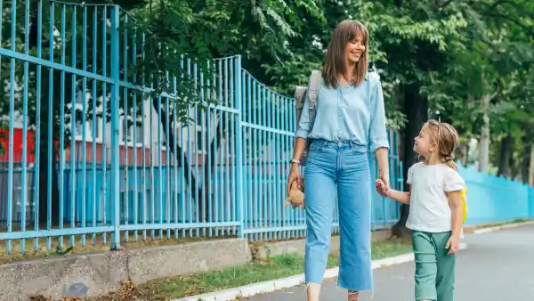 Happy Mother and daughter walking together, holding hands