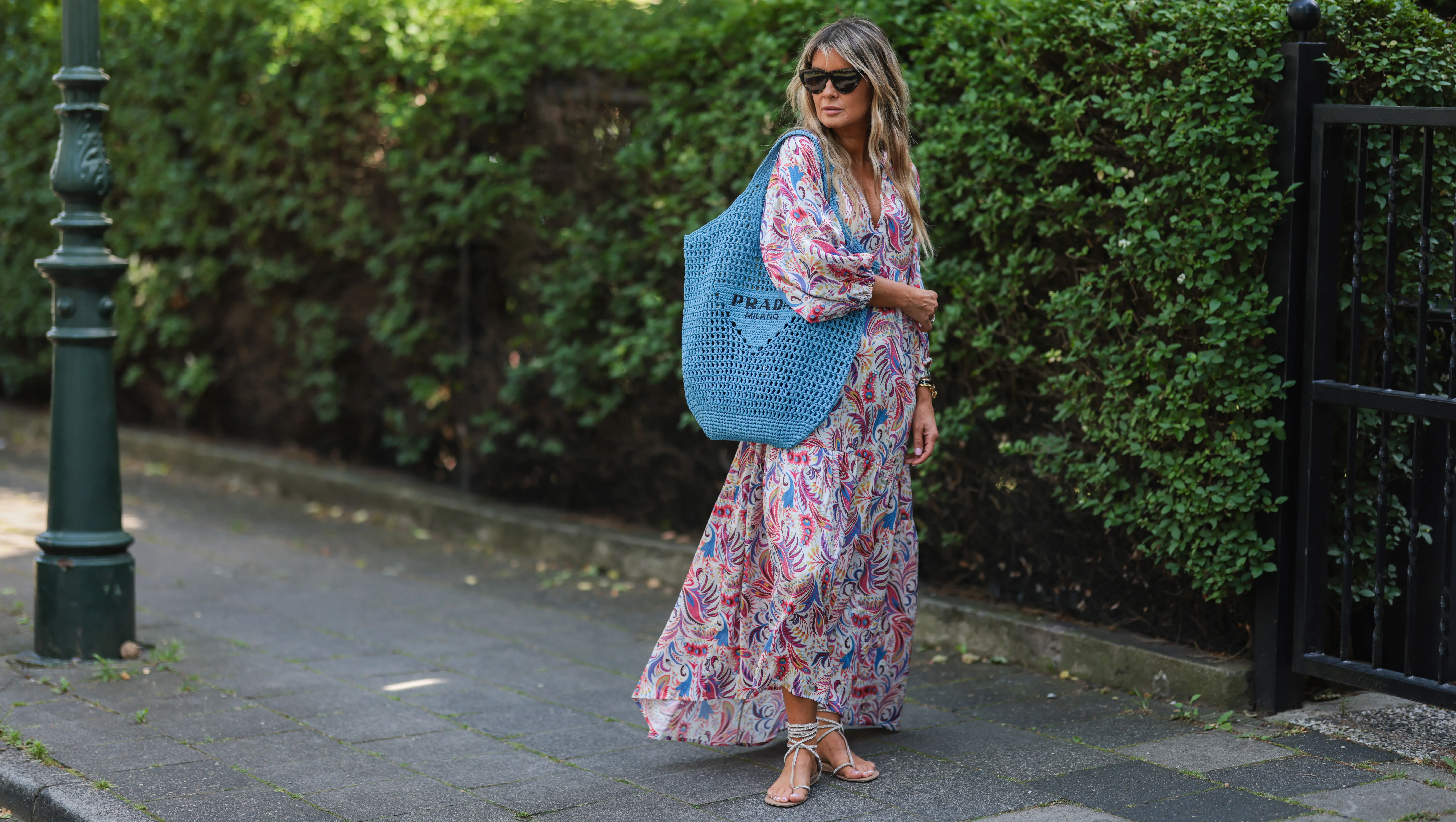 DUSSELDORF, GERMANY - JUNE 12: Gitta Banko seen wearing a Bottega Veneta sunglasses, a long maxi floral dress from Dea Kudibal with long sleeves, rhinestone sandals from Aminah Abdul Jillil and a blue bast raffia tote bag from Prada on June 12, 2022 in Dusseldorf, Germany. (Photo by Jeremy Moeller/Getty Images)