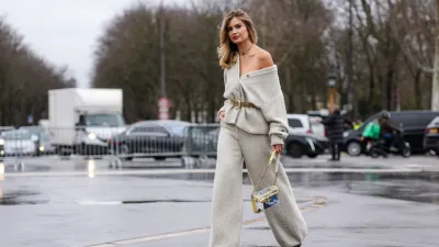 PARIS, FRANCE - JANUARY 28: Xenia Adonts wears silver necklace, light gray oversized Chanel tweed cardigan, light brown suede belt, light gray baggy Chanel tweed pants, light yellow transparent Chanel bag, outside Chanel, during the Haute Couture Spring/Summer 2025 on January 28, 2025 in Paris, France. (Photo by Edward Berthelot/Getty Images)