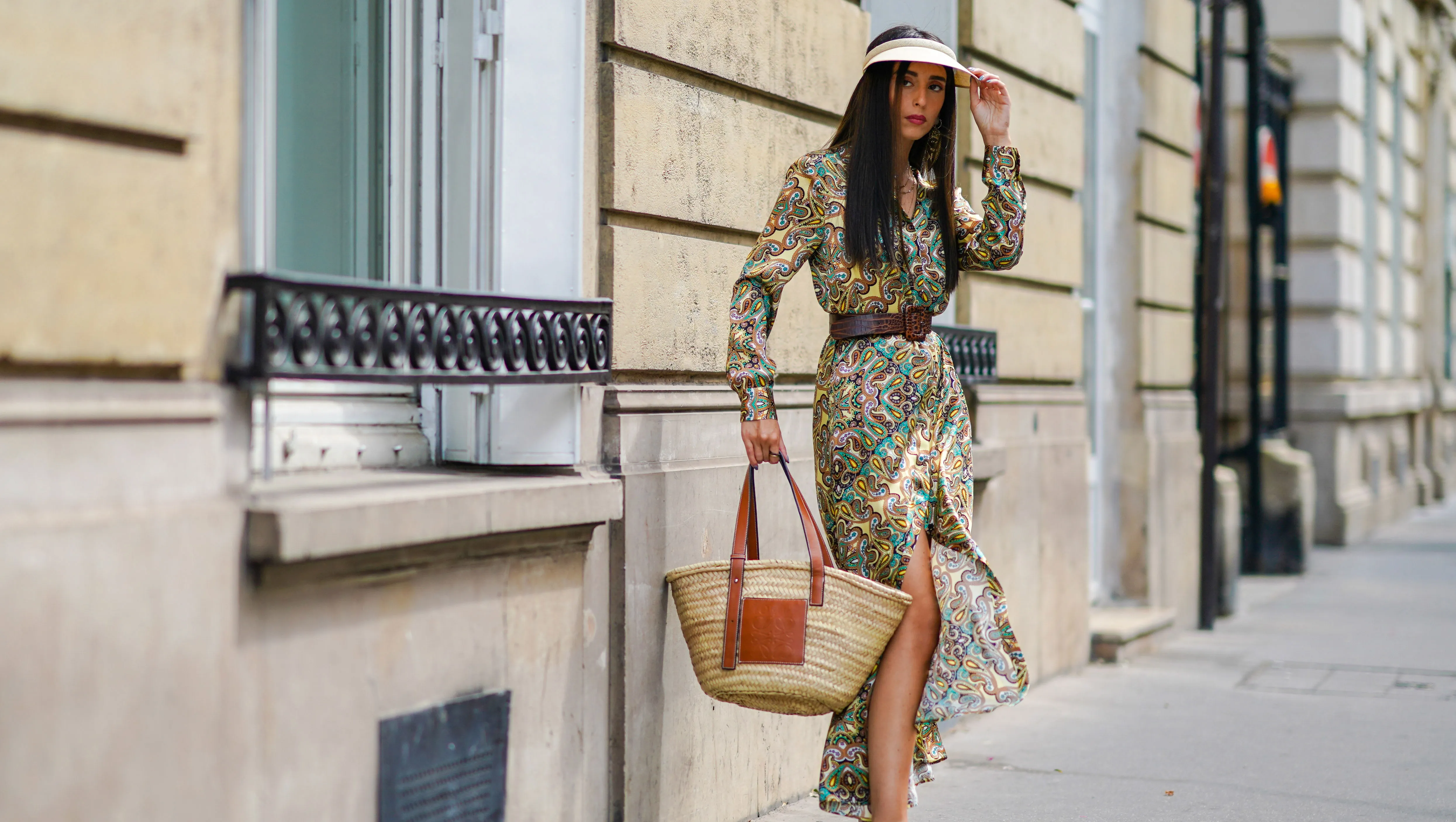 PARIS, FRANCE - JULY 15: Gabriella Berdugo wears a cap, a Maison Sarah Lavoine green floral print silky flowing dress, a Max Mara large brown leather belt, black leather gladiator sandals, a Loewe large summer basket straw bag with brown leather inserts, on July 15, 2020 in Paris, France. (Photo by Edward Berthelot/Getty Images)