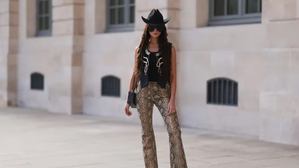 PARIS, FRANCE - OCTOBER 04: Sabina Jakubowicz seen wearing a Louis Vuitton petite malle bag, big shades by Gucci, Gucci animal print pants, a gold and black vest by Louis Vuitton, a Gucci cowboy hat and Louis Vuitton boots, outside Louis Vuitton during Paris Fashion Week on October 04, 2022 in Paris, France. (Photo by Jeremy Moeller/Getty Images)