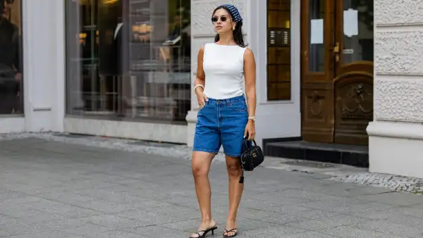 BERLIN, GERMANY - AUGUST 03: Bella Emar wears blue Polo Club Jeans Shorts & white Top, H&M sandals, Miu Miu Sunglasses & black Miu Miu bag, blue head scarf on August 03, 2025 in Berlin, Germany. (Photo by Christian Vierig/Getty Images)