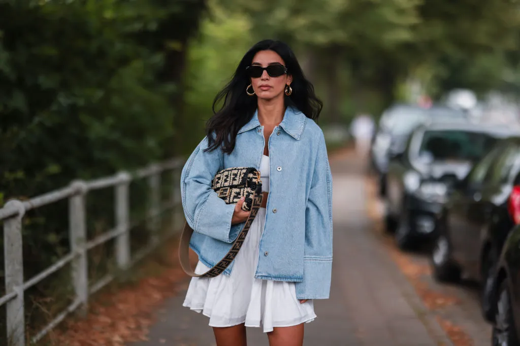 HAMBURG, GERMANY - JULY 27: Semra Hunt wearing Loewe jeans jacket, Fendi baguette and American Vintage white skirt and top on July 27, 2021 in Hamburg, Germany. (Photo by Jeremy Moeller/Getty Images)