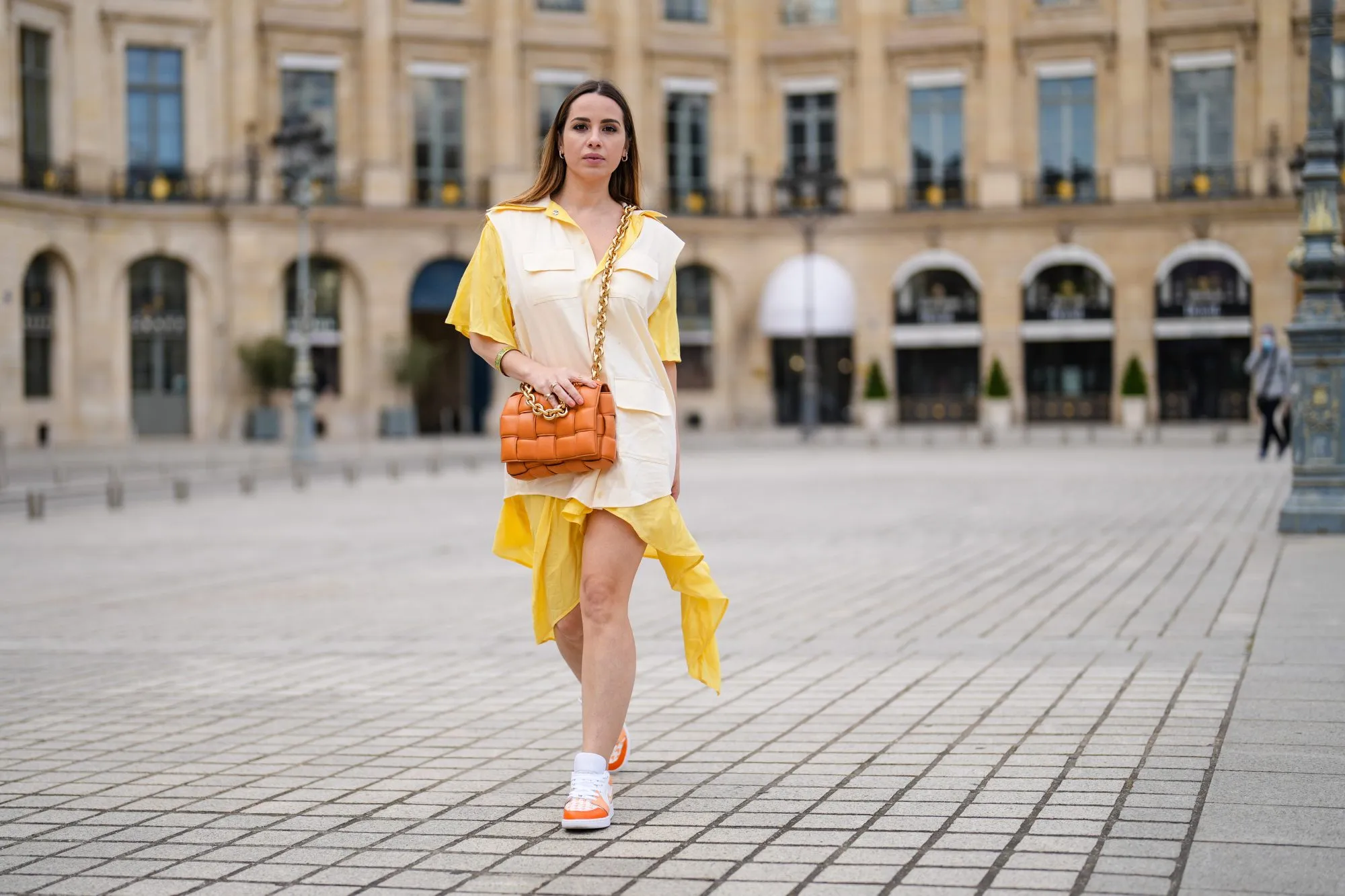 PARIS, FRANCE - MAY 07: Maria Rosaria Rizzo @lacoquetteitalienne wears a pale pastel yellow and beige shirt / flowing dress from Victoria/Tomas, a brown leather Bottega Veneta bag, sneakers from Nike Air Jordan with orange printed houndstooth patterns, on May 07, 2021 in Paris, France. (Photo by Edward Berthelot/Getty Images)