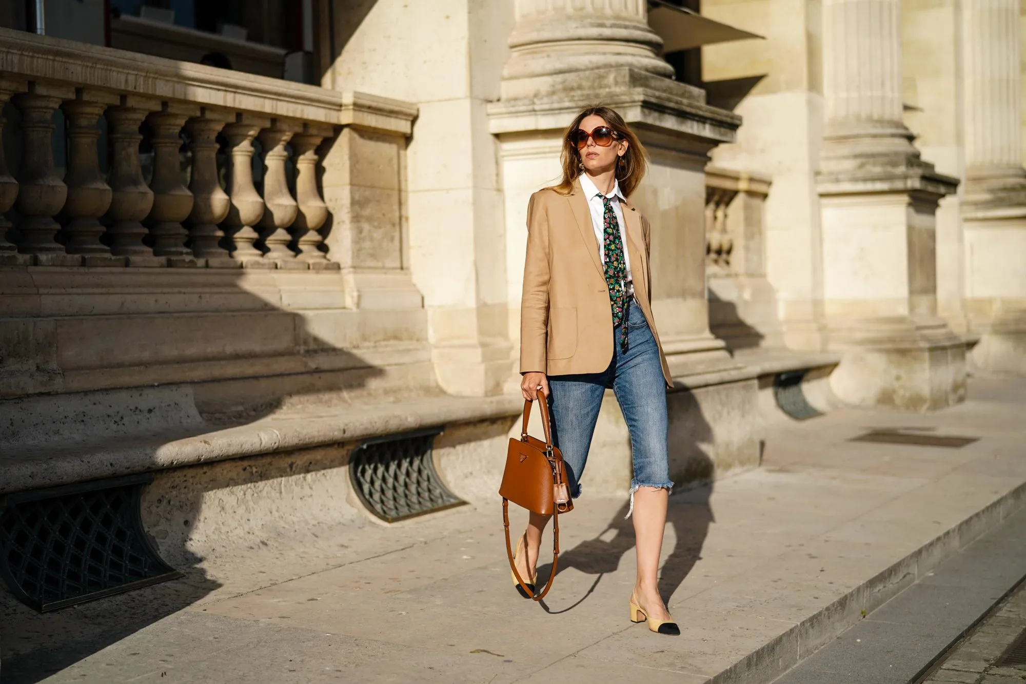 PARIS, FRANCE - AUGUST 03: Natalia Verza wears sunglasses from Celine, a Paul & Joe beige blazer jacket, a white shirt, a colored floral print tie from Paul & Joe, blue denim ripped short jeans, a Prada brown leather bag, Chanel slingback shoes, on August 03, 2020 in Paris, France. (Photo by Edward Berthelot/Getty Images)