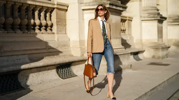 PARIS, FRANCE - AUGUST 03: Natalia Verza wears sunglasses from Celine, a Paul & Joe beige blazer jacket, a white shirt, a colored floral print tie from Paul & Joe, blue denim ripped short jeans, a Prada brown leather bag, Chanel slingback shoes, on August 03, 2020 in Paris, France. (Photo by Edward Berthelot/Getty Images)