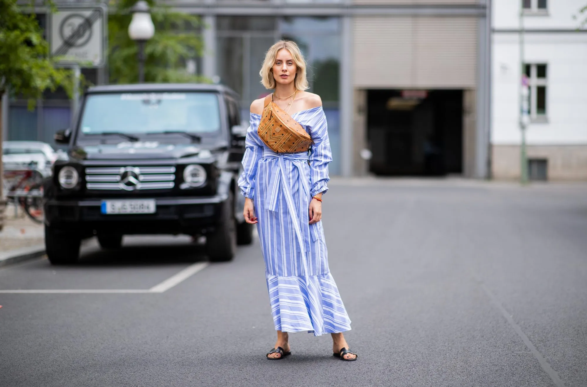 BERLIN, GERMANY - JULY 06: Lisa Hahnbueck wearing striped off shoulder dress Mykke Hofmann, MCM Stark fanny belt bag, Hermes Oran sandals seen during the Berlin Fashion Week July 2018 on July 6, 2018 in Berlin, Germany. (Photo by Christian Vierig/Getty Images)