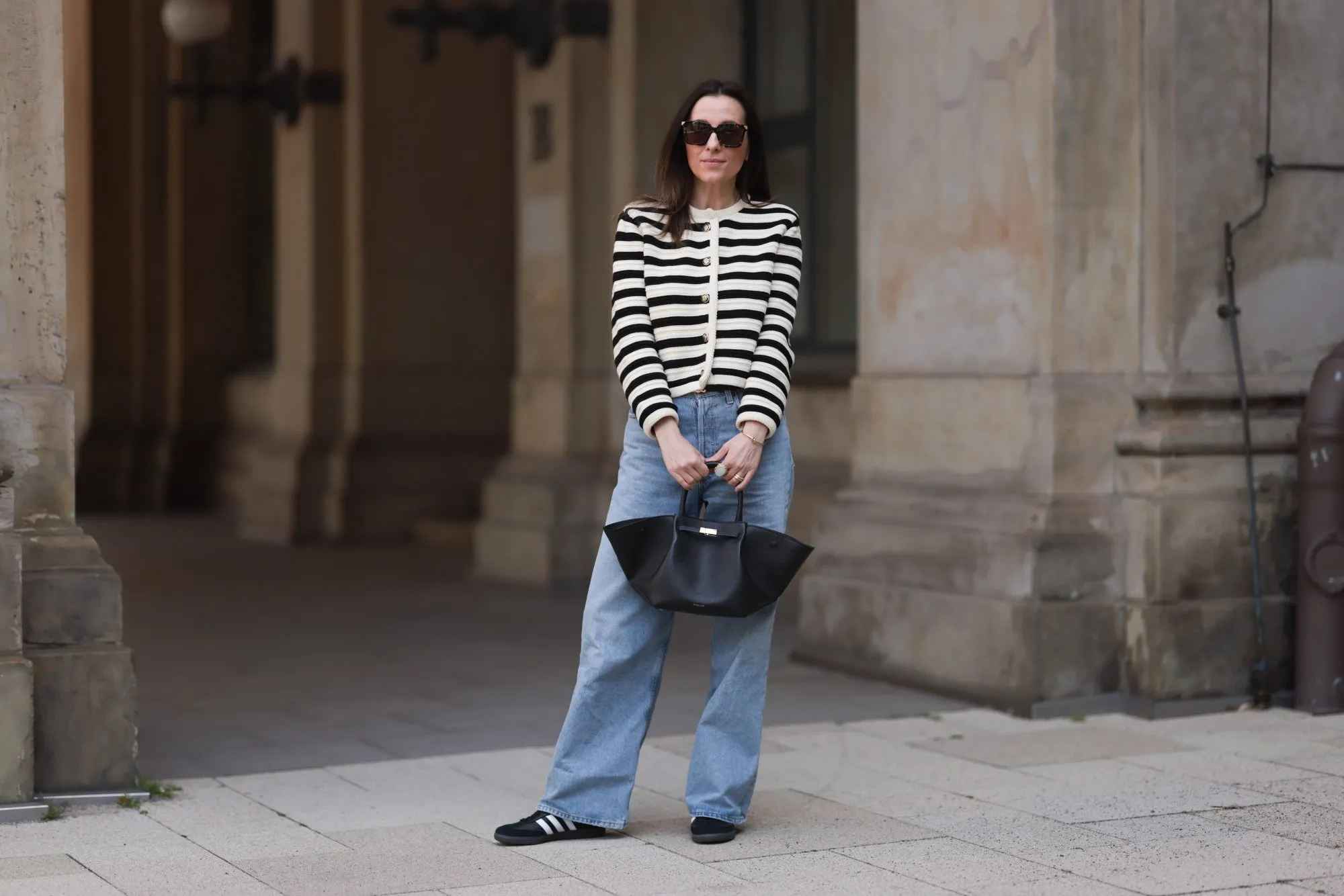 HAMBURG, GERMANY - MAY 09: Elise Seitz seen wearing Bottega Veneta black shades, Celine black belt, Adidas black samba sneaker, Agolde blue jeans, Massimo Dutti striped black and white cardigan and Demellier black bag on May 09, 2023 in Hamburg, Germany. (Photo by Jeremy Moeller/Getty Images)