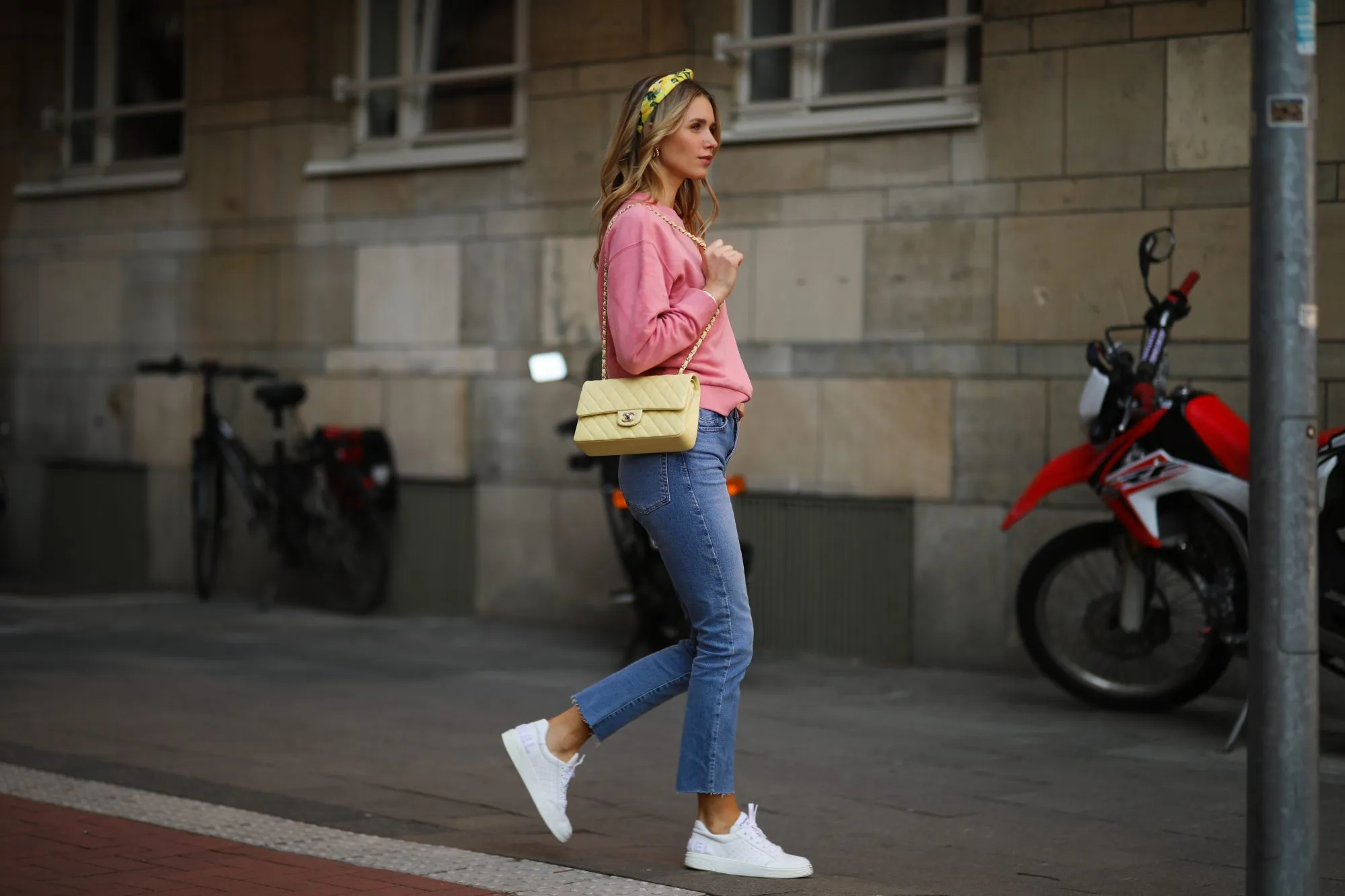 DUSSELDORF, GERMANY - MARCH 24: Scarlett Gartmann wearing pink Vogue sweater, Zara blue jeans, yellow H&M headband, yellow Chanel leather bag and white Chanel sneakers on March 24, 2021 in Dusseldorf, Germany. (Photo by Jeremy Moeller/Getty Images)