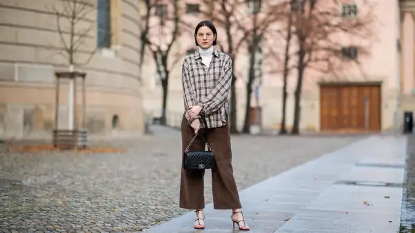 BERLIN, GERMANY - JANUARY 15: Maria Barteczko is seen wearing white turleneck COS, brown checked shirt Zara, brown corduroy pants Zara, black leather strap sandals Zara, black bag Chanel boy, gold round retro glasses Ray Ban during the Berlin Fashion Week Autumn/Winter 2019 on January 15, 2019 in Berlin, Germany. (Photo by Christian Vierig/Getty Images)