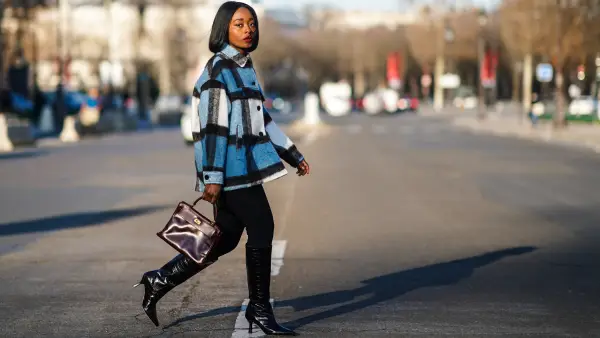 PARIS, FRANCE - JANUARY 09: Carrole Sagba aka "Linaose" wears a blue and white checked wool jacket from Zara, a purple / burgundy leather Hermes Birkin bag, black leggings/pants from Acne Studios, black pointy high heeled knee-high leather boots with printed crocodile patterns from Dear Frances, on January 09, 2021 in Paris, France. (Photo by Edward Berthelot/Getty Images)