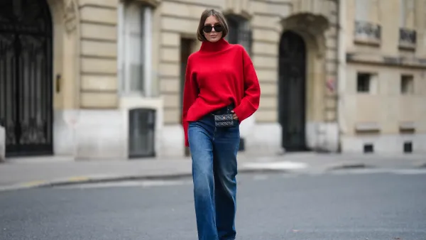 PARIS, FRANCE - NOVEMBER 10: Diane Batoukina wears black sunglasses, a red wool ribbed turtleneck pullover, a black shiny leather belt bag from Chanel, blue faded denim wide legs pants, red shiny varnished leather pointed pumps heels shoes, during a street style fashion photo session, on November 10, 2022 in Paris, France. (Photo by Edward Berthelot/Getty Images)