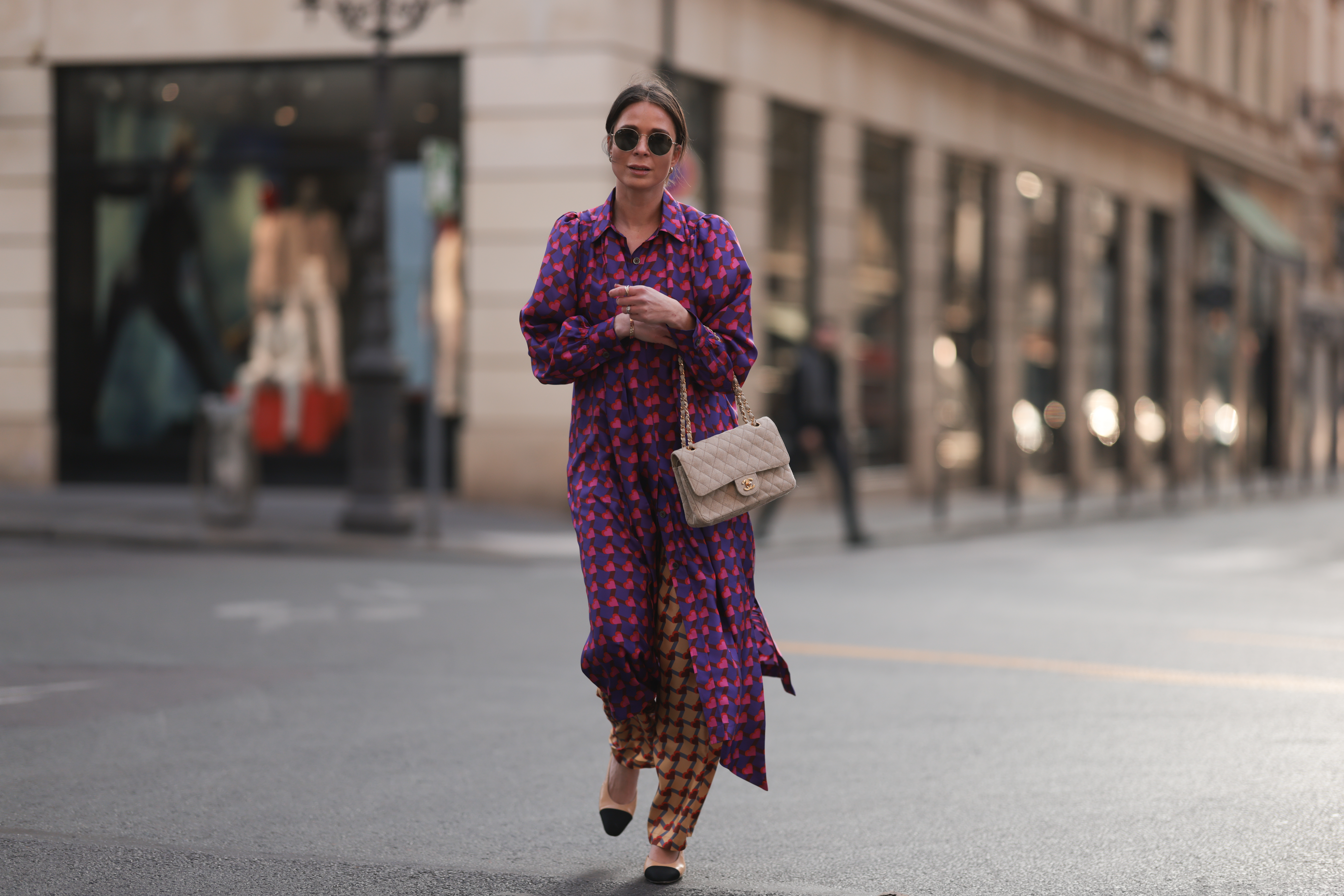 PARIS, FRANCE - MARCH 04: Patricia Wirschke seen wearing Ray-Ban gold round sunglasses, Odeeh purple / pink heart print pattern button maxi silk dress with long sleeves, Odeeh beige / red print pattern long silk pants, Chanel beige fabric flap bag, Chanel beige / black slingback leather heels / pumps, during Paris Fashion Week - Womenswear Fall Winter 2023 2024, on March 04, 2023 in Paris, France. (Photo by Jeremy Moeller/Getty Images)