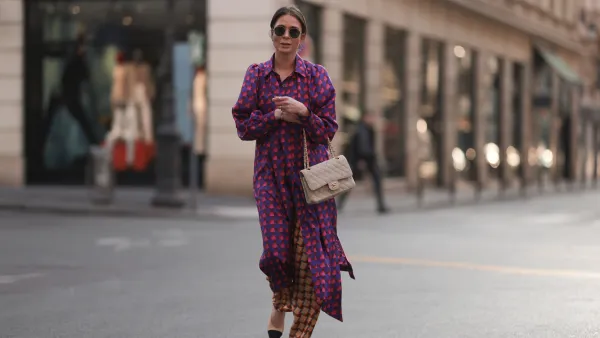 PARIS, FRANCE - MARCH 04: Patricia Wirschke seen wearing Ray-Ban gold round sunglasses, Odeeh purple / pink heart print pattern button maxi silk dress with long sleeves, Odeeh beige / red print pattern long silk pants, Chanel beige fabric flap bag, Chanel beige / black slingback leather heels / pumps, during Paris Fashion Week - Womenswear Fall Winter 2023 2024, on March 04, 2023 in Paris, France. (Photo by Jeremy Moeller/Getty Images)