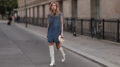 BERLIN, GERMANY - MAY 14: Nadine Berneis seen wearing Prada blue denim midi logo dress, Zara beige over knee boots, Bottega Veneta mini Jodie porridge beige leather bag on May 14, 2023 in Berlin, Germany. (Photo by Jeremy Moeller/Getty Images)