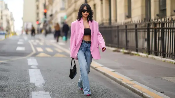 PARIS, FRANCE - JULY 07: Xiayan wears black sunglasses, silver earrings, a black headband t-shirt, a pale pink oversized blazer jacket, a black grained leather belt, blue faded denim jeans ripped flared pants, rings, a black shiny leather Prada handbag, red shiny pointed pumps heels shoes, outside Zuhair Murad, during Paris Fashion Week - Haute Couture Fall/Winter 2021/2022, on July 07, 2021 in Paris, France. (Photo by Edward Berthelot/Getty Images)