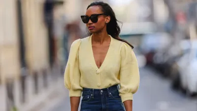 PARIS, FRANCE - APRIL 03: Emilie Joseph @in_fashionwetrust wears sunglasses, pale pastel yellow a puffed sleeves wool cardigan from Mango, high rise blue denim jeans pants from Levi's, on April 03, 2021 in Paris, France. (Photo by Edward Berthelot/Getty Images)