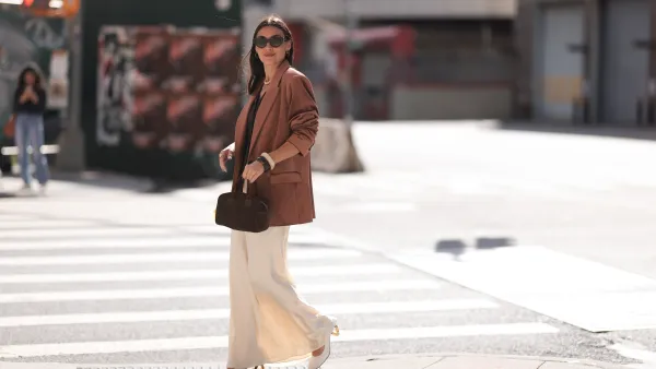 NEW YORK, NEW YORK - SEPTEMBER 08: Yana Echko seen wearing YSL brown sunglasses, Bottega Veneta brown leather earrings, white pearl necklace, The Frankie Shop brown pinstripe vest, Express light brown corduroy blazer jacket, Reformation cream white maxi silk long skirt, MARGE SHERWOOD brown suede leather small bag, Kenneth Jay Lane gold ring, cream white / brown bangle and JW Anderson white leather pumps, outside the Bach Mai show, during the New York Fashion Week, on September 08, 2024 in New York City. (Photo by Jeremy Moeller/Getty Images)