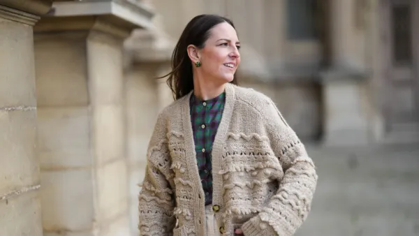PARIS, FRANCE - MARCH 27: Alba Garavito Torre wears gold and green cross print pattern earrings, a green and purple checkered print pattern / puffy shoulder / buttoned shirt from Nina Blanc, high waist ivory high waist wide legs pants from Nina Blanc, a beige wool embroidered pattern oversized buttoned cardigan , during a street style fashion photo session, on March 27, 2023 in Paris, France. (Photo by Edward Berthelot/Getty Images)