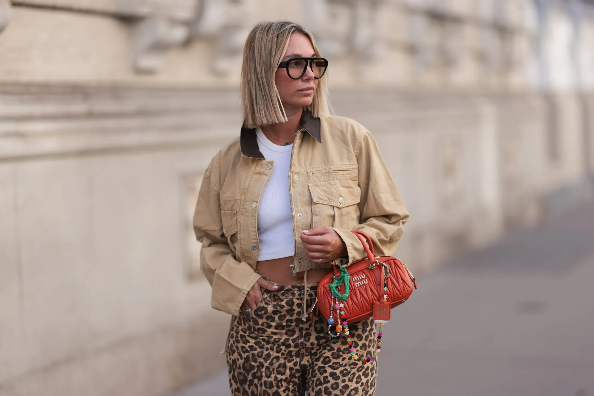 VIENNA, AUSTRIA - AUGUST 26: Karin Teigl seen wearing Andy Wolf black sunglasses, By Aylin Koenig white cotton basic cropped shirt, Bershka brown animal printed oversized long pants, Zara beige cropped cord jacket, Miu Miu orange leather Arcadie bag with colorful bag charms, on August 26, 2024 in Vienna, Austria. (Photo by Jeremy Moeller/Getty Images)