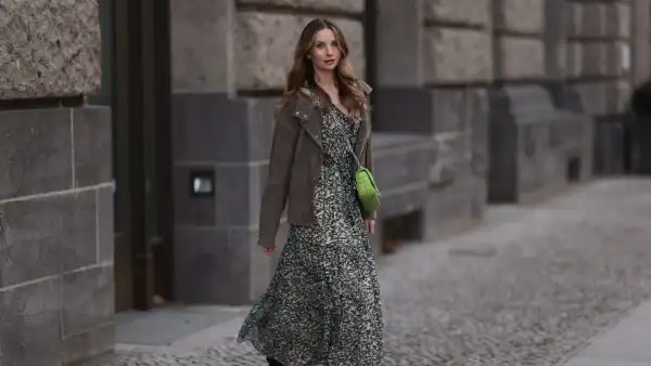 BERLIN, GERMANY - FEBRUARY 16: Anna Hiltrop seen wearing Boss green / beige / black print pattern pleated long dress, Boss brown suede leather jacket, Michael Kors green leather quilted crossbody bag and Gucci black leather laced boots, on February 16, 2024 in Berlin, Germany. (Photo by Jeremy Moeller/Getty Images)