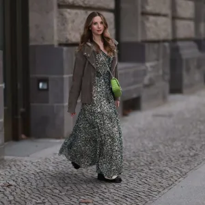 BERLIN, GERMANY - FEBRUARY 16: Anna Hiltrop seen wearing Boss green / beige / black print pattern pleated long dress, Boss brown suede leather jacket, Michael Kors green leather quilted crossbody bag and Gucci black leather laced boots, on February 16, 2024 in Berlin, Germany. (Photo by Jeremy Moeller/Getty Images)