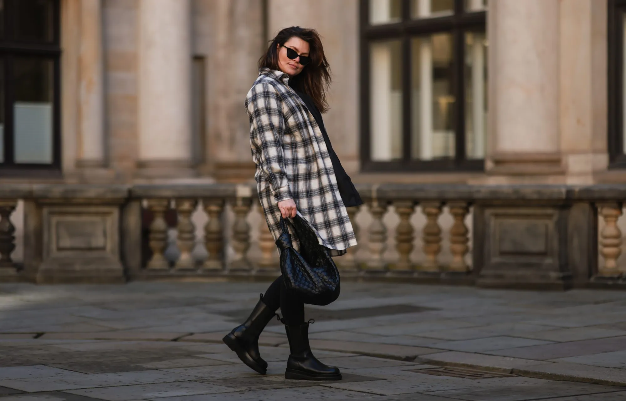 HAMBURG, GERMANY - FEBRUARY 07: Dayami Candebat is seen wearing Kaffe curve long flanell, Ducie black boots, big Bottega Veneta Jodie black leather bag, Prada black shades, cap and beige jacket on February 07, 2022 in Hamburg, Germany. (Photo by Jeremy Moeller/Getty Images)