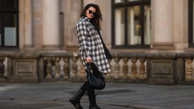 HAMBURG, GERMANY - FEBRUARY 07: Dayami Candebat is seen wearing Kaffe curve long flanell, Ducie black boots, big Bottega Veneta Jodie black leather bag, Prada black shades, cap and beige jacket on February 07, 2022 in Hamburg, Germany. (Photo by Jeremy Moeller/Getty Images)