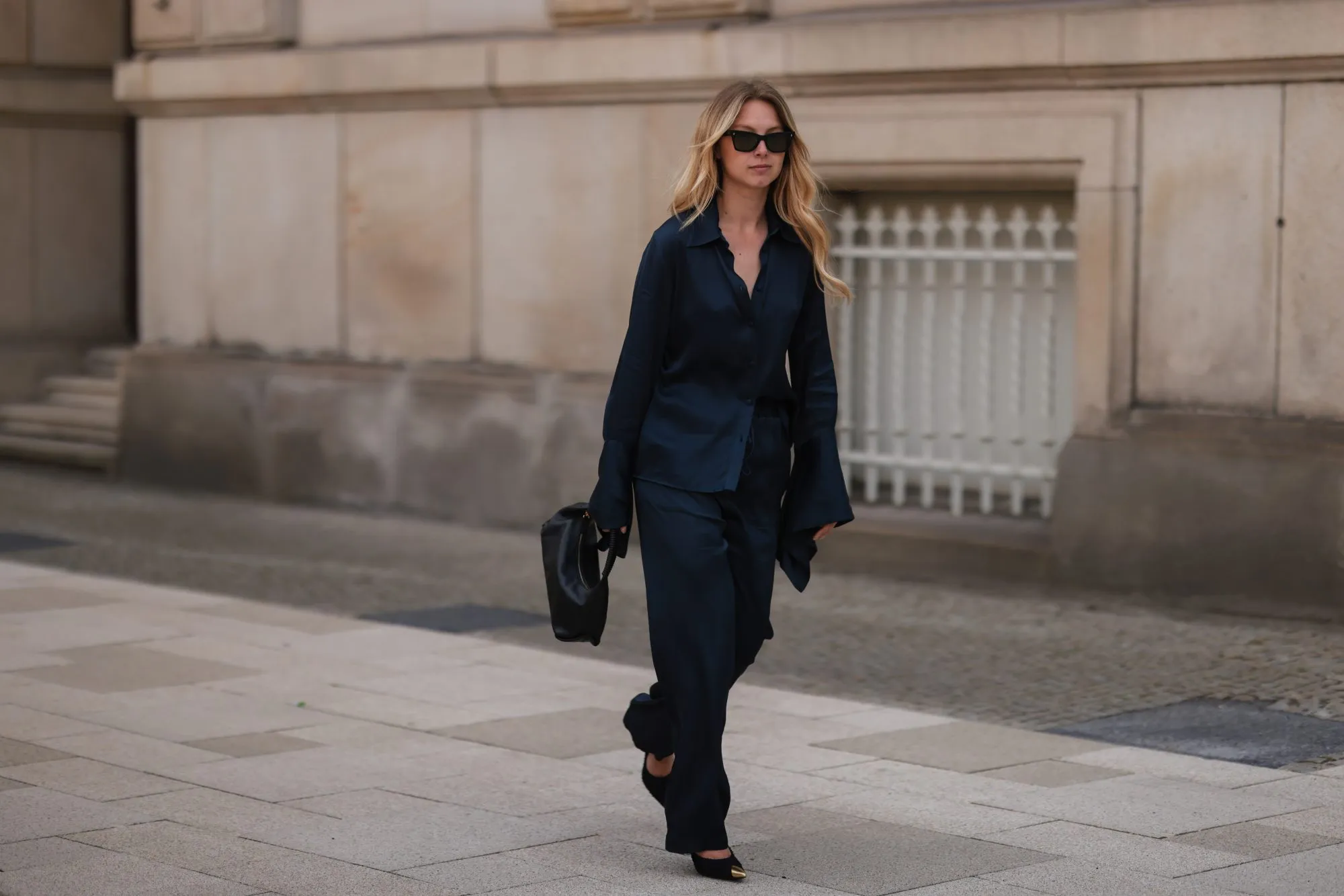 HAMBURG, GERMANY - JUNE 09: Liesa Sp&auml;ht seen wearing black sunglasses from Celine, a dark blue silk blouse from SoSue, a matching dark blue silk wide leg pants from SoSue, black heels from Saint Laurent and a black leather Khaite bag on June 09, 2022 in Hamburg, Germany. (Photo by Jeremy Moeller/Getty Images)