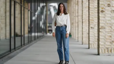 COPENHAGEN, DENMARK - AUGUST 07: Astrid Boutrot wears a white blouse featuring ruffled detailing along the front and cuffs, paired with high-waisted blue denim jeans. The ensemble is accessorized with a black and white patterned belt. Black ankle boots complete the outfit. Hair is styled straight and loose, outside Birrot, during Copenhagen Fashion Week, on August 07, 2025 in Copenhagen, Denmark (Photo by Edward Berthelot/Getty Images)