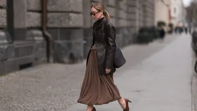 BERLIN, GERMANY - MARCH 24: Sonia Lyson seen wearing Givenchy chic brown oval-framed sunglasses with a subtle vintage touch, Tods dark chocolate brown fitted turtleneck with delicate sheer stripes and ruffled collar details, elegantly tucked into a Tods statement high-waisted draped skirt in earthy brown with a gathered waistband and silver-toned belt accents, Tods structured dark brown leather blazer with sharp tailoring adds a sophisticated edge, Tods sleek black leather Magenta bucket bag with a gold-tone metal frame and Tods classic brown leather block-heel pumps, on March 24, 2025 in Berlin, Germany. (Photo by Jeremy Moeller/Getty Images)