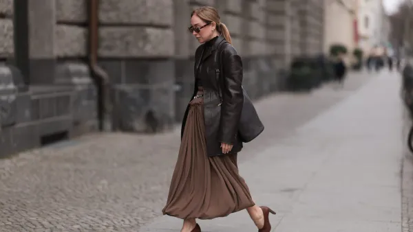 BERLIN, GERMANY - MARCH 24: Sonia Lyson seen wearing Givenchy chic brown oval-framed sunglasses with a subtle vintage touch, Tods dark chocolate brown fitted turtleneck with delicate sheer stripes and ruffled collar details, elegantly tucked into a Tods statement high-waisted draped skirt in earthy brown with a gathered waistband and silver-toned belt accents, Tods structured dark brown leather blazer with sharp tailoring adds a sophisticated edge, Tods sleek black leather Magenta bucket bag with a gold-tone metal frame and Tods classic brown leather block-heel pumps, on March 24, 2025 in Berlin, Germany. (Photo by Jeremy Moeller/Getty Images)
