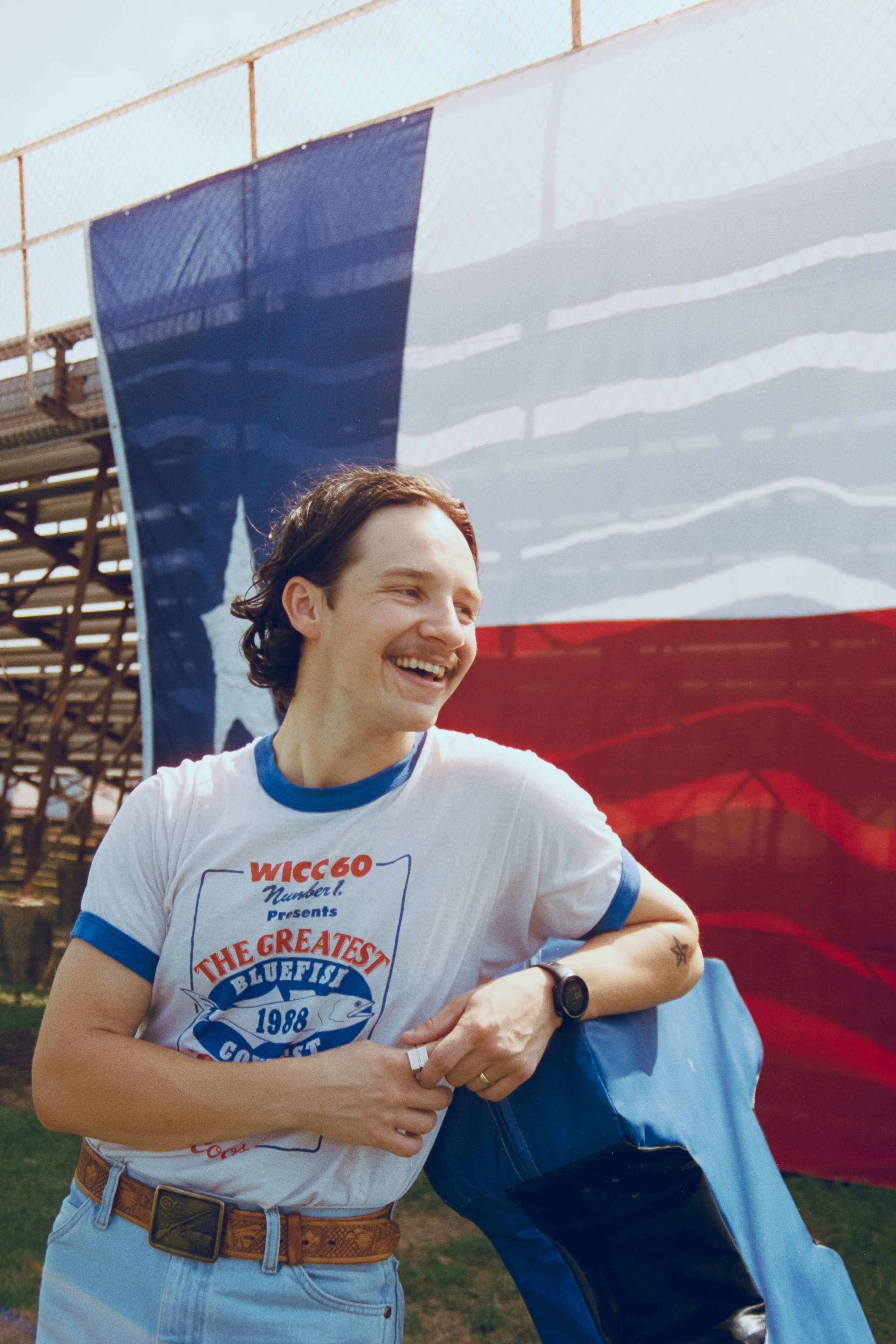 Jack Blocker posing in front of a Texas flag.