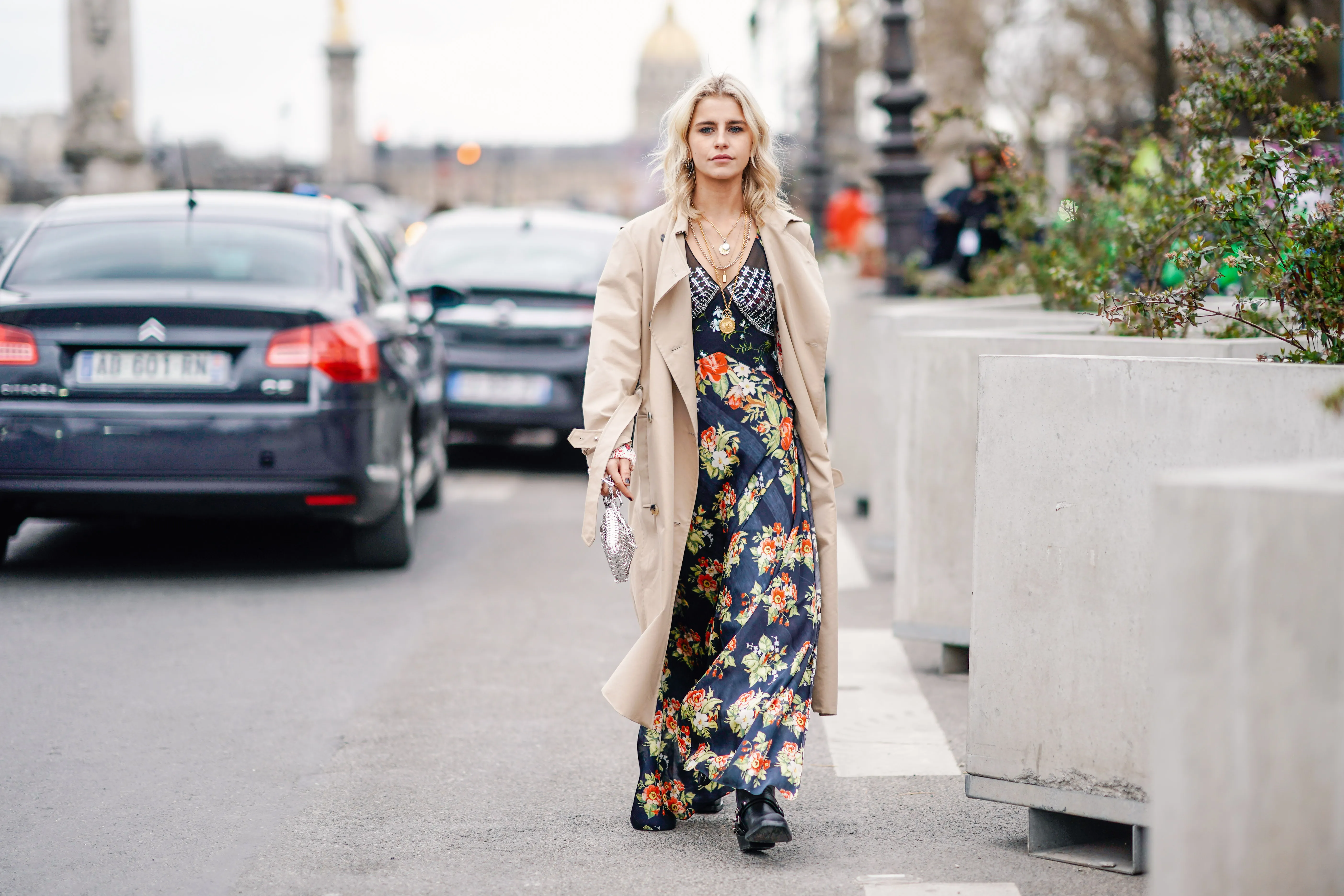 PARIS, FRANCE - FEBRUARY 28: Caroline Daur wears a trench coat, a floral print dress, a silver bag, a necklace, outside Paco Rabanne, during Paris Fashion Week Womenswear Fall/Winter 2019/2020, on February 28, 2019 in Paris, France. (Photo by Edward Berthelot/Getty Images)